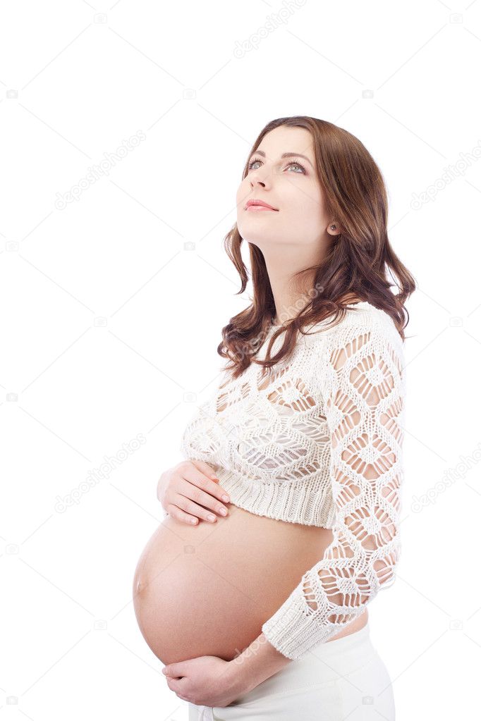 Pregnant dreaming woman holding belly looking up