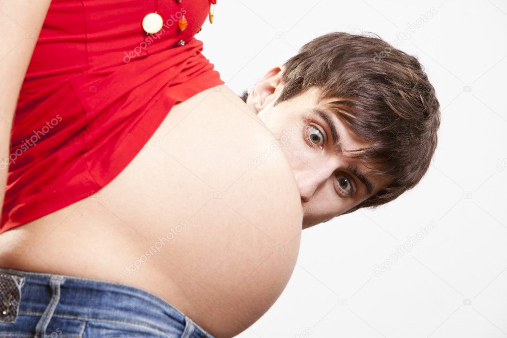 Surprised man peek out from behind the pregnant belly