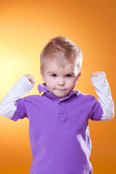 Lindo chico mostrando fortaleza con las manos arriba — Foto de Stock