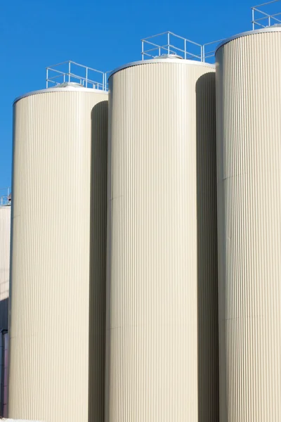 Tanques de almacenamiento de aceite de refinería y cielo azul claro en segundo plano —  Fotos de Stock