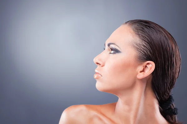 Профиль уверенной женщины с черно-золотым макияжем — стоковое фото
