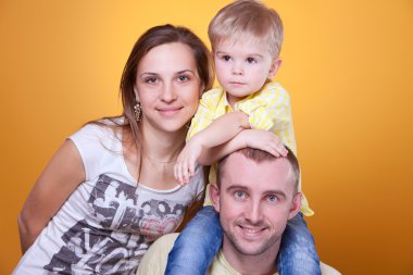 Young parents with little son on father's shoulders clipart