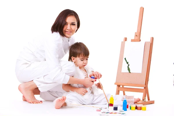 Son and mom dressed in white painting near easel — Stock Photo, Image