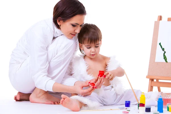 Mom and son dressed in white learning to paint near easel — Stock Photo, Image
