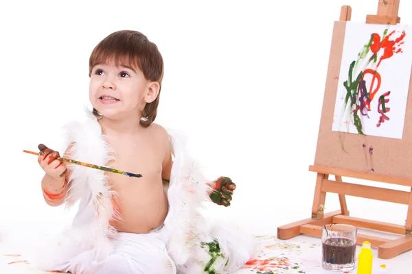 Usmívající se dítě drží kartáč s malovanými špinavé ruce — Stock fotografie