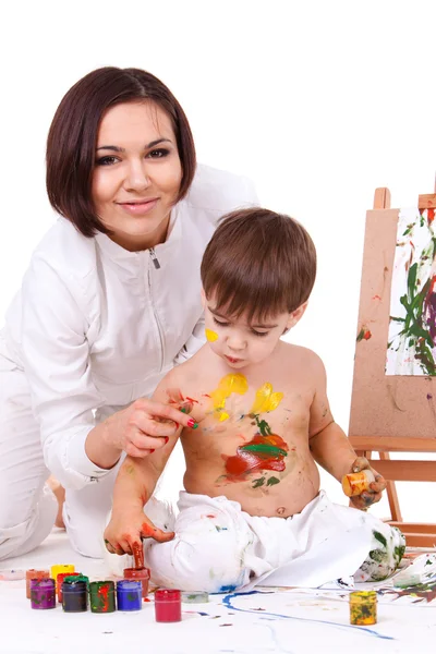 Bromeando madre en blanco pintando las manos de su hijo — Foto de Stock