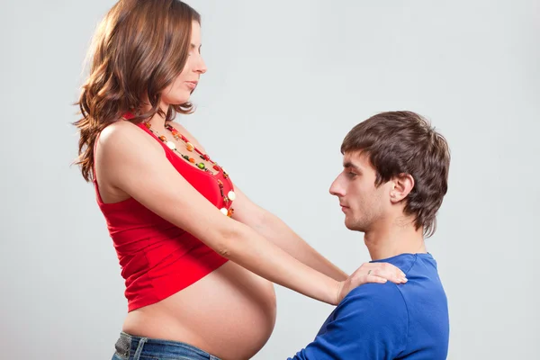 彼の妻の妊娠中の腹を見て驚くほどの男 ストック画像
