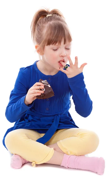 Hungry girl lick fingers dirty with cake — Stock Photo, Image