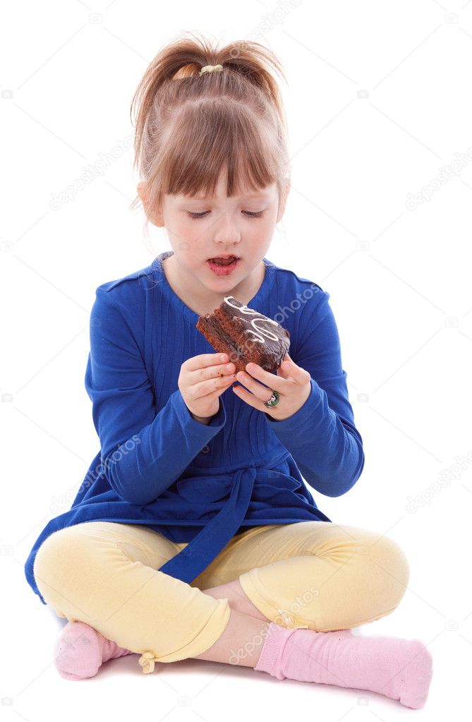Hungry little girl eating cake