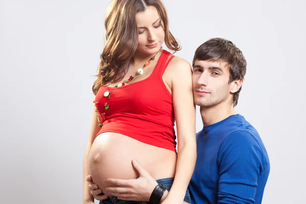 Man omfamnar sin fru gravid mage — Stockfoto