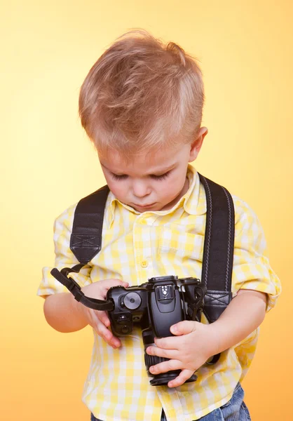 Little smiling photographer watching photo on camera — Stock Photo, Image