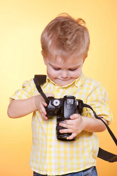Little smiling photographer watching photo on camera