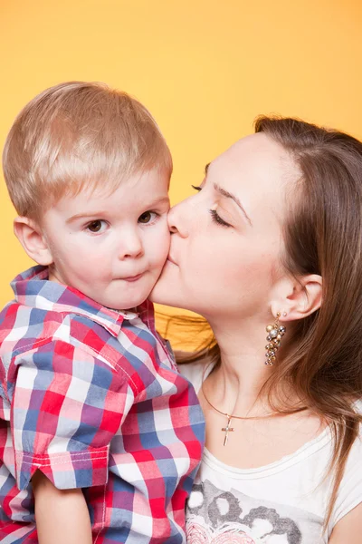 Счастливая мама целует маленького сына — стоковое фото