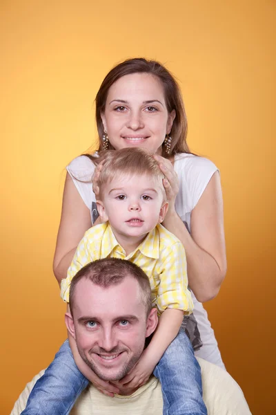 Lyckliga föräldrar med lille son på pappas axlar — Stockfoto
