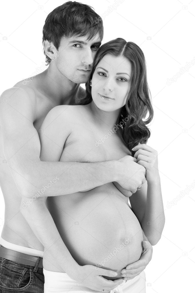 Happy couple embracing with pregnant belly