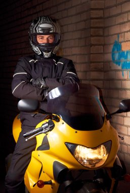 Motorcu siyah palto ve, sarı spor motosiklet kask