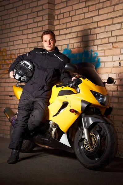 Motociclista Casaco Preto Segurando Capacete Motocicleta Esporte Amarelo — Fotografia de Stock