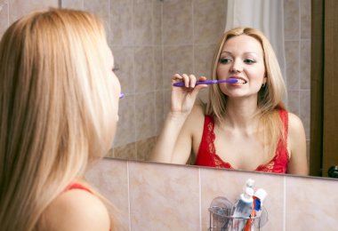 Young pretty woman brushing her teeth clipart