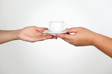 Female giving cup of coffee to another woman clipart