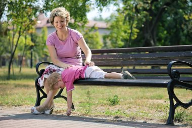 mutlu anne ve oğlu bir şehir parkta bankta oturmuş