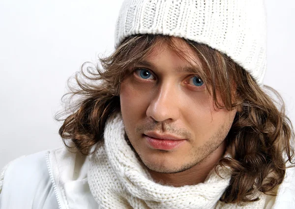 Portrait of young man in knitted hat and scarf on white background in the studio — Stock Photo, Image