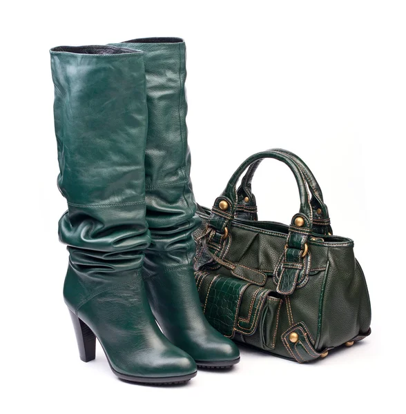 Gröna kvinnliga högklackade stövlar och läderväska på den vita bakgrunden — Stockfoto