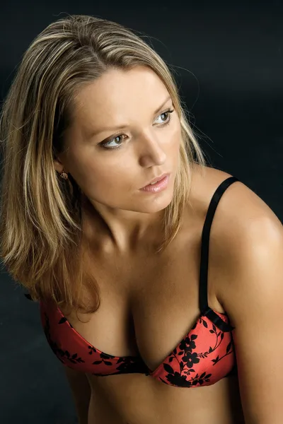 Retrato de jovem mulher sexy em lingerie vermelha no fundo preto — Fotografia de Stock