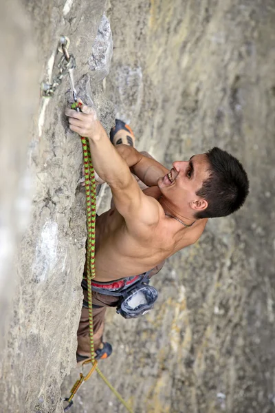 Rock climber on the cliff, vertical view