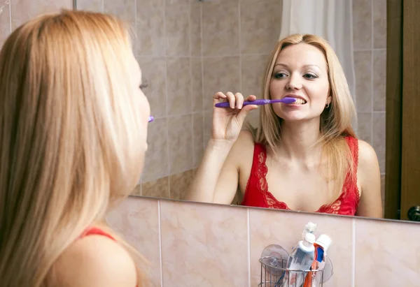 Unga vackra kvinnan borsta hennes tänder — Stockfoto