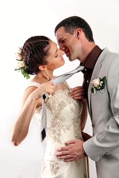 Bride pulling groom by his tie for a kiss — Stock Photo, Image