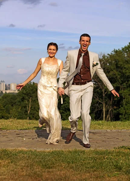 Gifter seg bare med et lykkelig par løpende i parken. – stockfoto