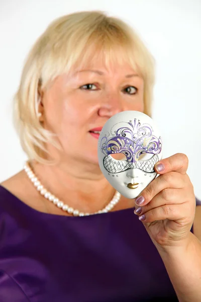 Привлекательная зрелая женщина, держащая венецианскую маску — стоковое фото