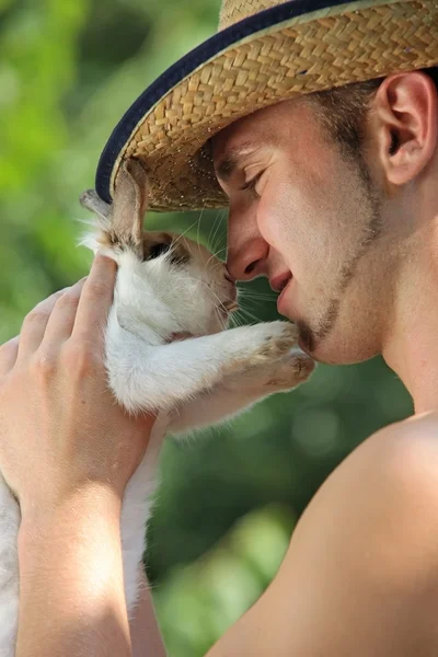 Portrait of young handsome man holding his pet rabbit, outdoor shot — Stock Photo, Image