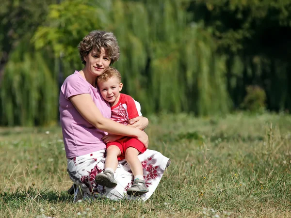 Happy mother and son in park on summer day — Stock Photo, Image