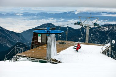 Station of the ski lift, female skier on chairlift. clipart