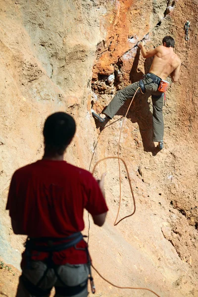 Two rock climbers, one belaying — Stock Photo, Image