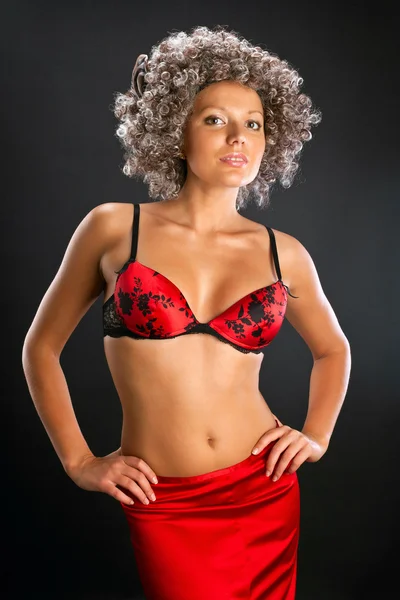 Peruk ve kırmızı iç çamaşırı siyah arka plan üzerine güzel bir genç kadın — Stok fotoğraf