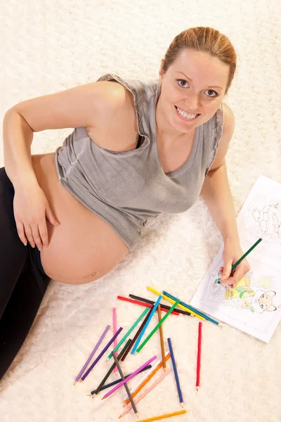 漂亮怀孕女人用铅笔绘图 — 图库照片