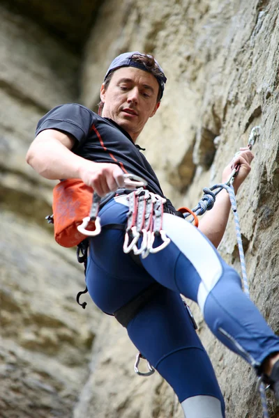 Rock climber going to fix quickdraw to rock — Stock Photo, Image