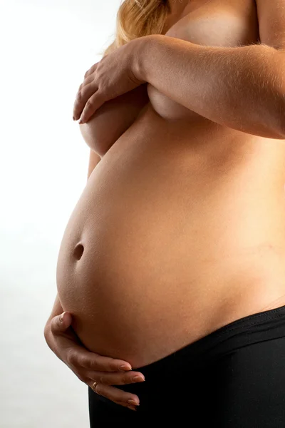 Обнажённая беременная женщина на белом фоне — стоковое фото
