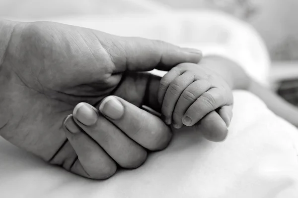 Mano del bebé sosteniendo el dedo de la madre — Foto de Stock