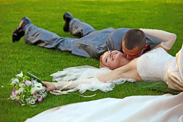 Portrait of happy newlyweds on grass — Stock Photo, Image
