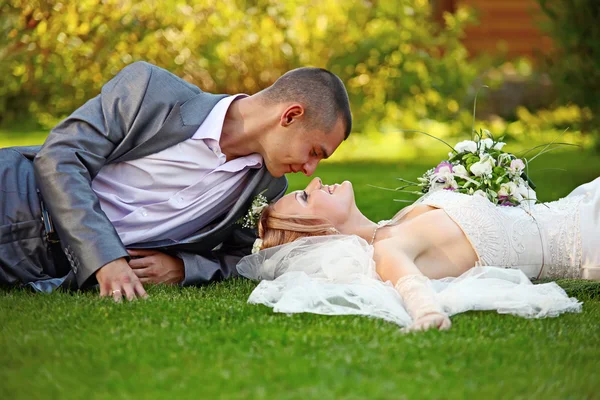 Portrait of happy newlyweds on grass — Stock Photo, Image