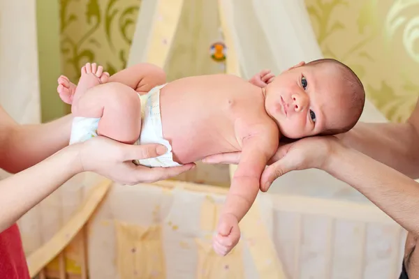 Yeni doğan bir bebek tutan anne ve babasının ellerini — Stok fotoğraf