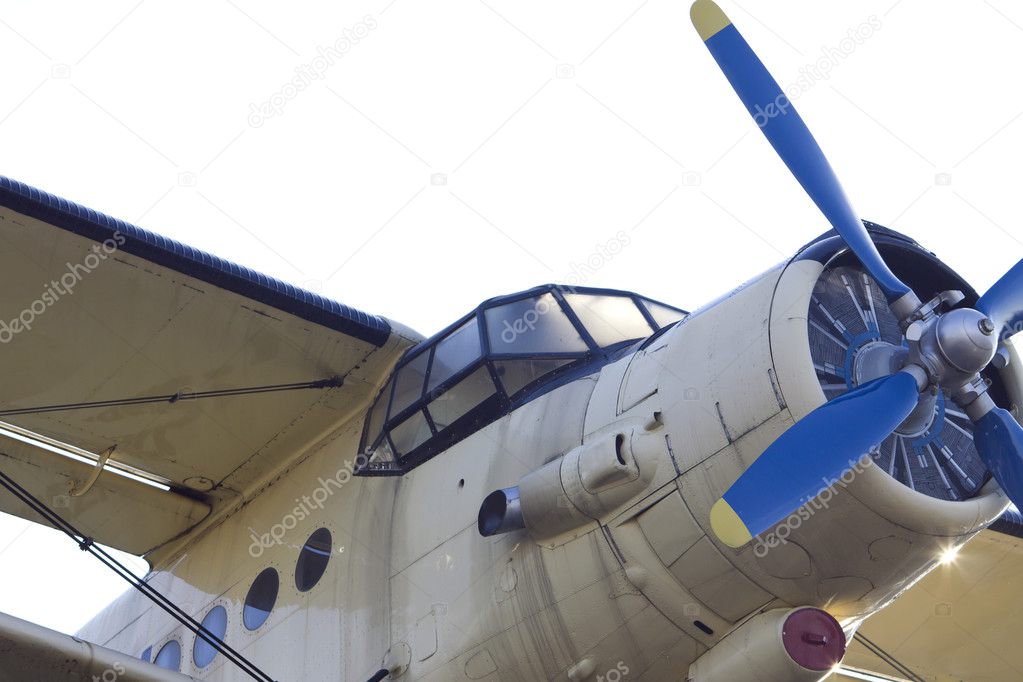 Cockpit of vintage biplane with blue propeller.