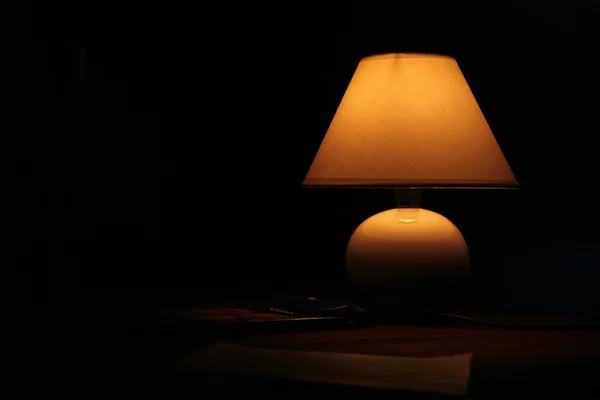 暗闇の中でテーブルの上の古代のランプ ストック写真