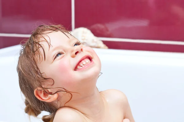 Schattig twee-jaar-oude meisje op zoek uit een bad en glimlachen — Stockfoto