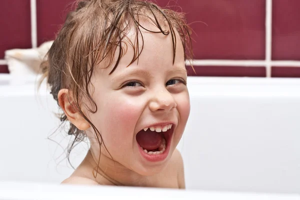 Linda chica de dos años de edad, mirando desde un baño y sonriendo —  Fotos de Stock