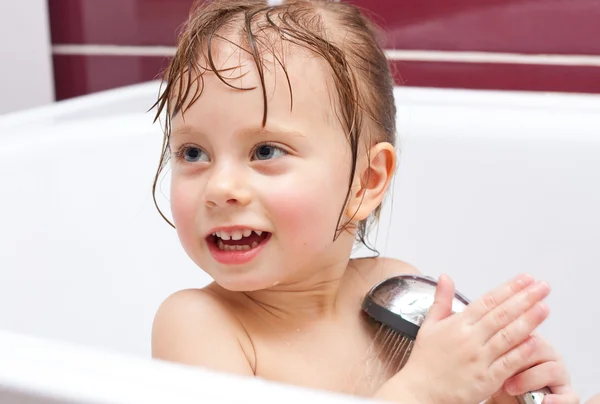Sød tre-årig pige ser ud af et bad og smiler - Stock-foto