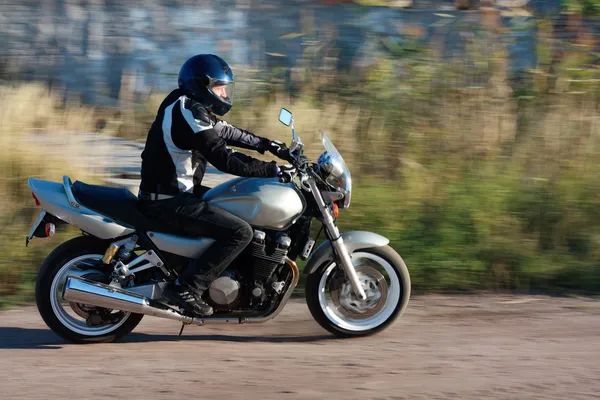 Człowiek jazda na motocyklu na drodze Zdjęcie Stockowe